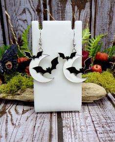 These cute earrings feature white crescent moon charms with black bats flying over it. The charms have a black and white enamel inlay. They have nickle free silver plated ear wires.  Earrings are 1 3/4" total length *Color may vary slightly due to individual viewing monitors Store policies: https://www.etsy.com/shop/eternalnightboutique#policies I ship Monday - Friday before 12pm EST. Back to the shop:  https://www.etsy.com/shop/eternalnightboutique *Due to rising costs of paper and ink and in a Handmade Black Vampire Earrings, Black Moon-shaped Halloween Jewelry, Black Moon Shaped Jewelry For Halloween, Black Moon-shaped Jewelry For Halloween, Black Halloween Moon Charm Jewelry, Black Moon Charm Jewelry For Halloween, Bat Flying, Bat Jewelry, White Moon