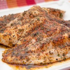 baked fish on a white plate sitting on a checkered tablecloth with text overlay