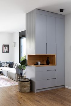 a living room filled with furniture next to a window and a wooden flooring area