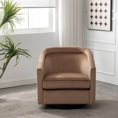 a tan leather chair sitting in front of a potted plant