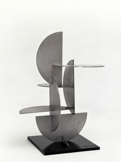 an abstract metal sculpture on a black stand