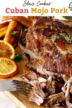 a large piece of meat sitting on top of a cutting board next to sliced oranges