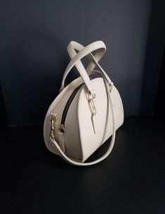 "For your consideration is this beautiful and oh so rare, vintage Coach Chadwick Bag, or Bowler (style #9928) in Bone or ivory-white, with brass hardware.  It is a \"Leatherware Era\" bag, and was made in the United Sates before 1994.  It is in Mint restored condition.  I consider this bag to be the Grail of vintage Coach purses, and is one of the most beautiful bags that Coach made during this era.  It is my favorite, and especially rare in bone.  The Chadwick satchel is a unique Coach style th White Bag With Gold-tone Hardware And Round Handle, White Bags With Gold-tone Hardware And Round Handle, Luxury Cream Handheld Bag, Beige Satchel With Handle Drop For Formal Occasions, Formal Beige Satchel With Handle Drop, White Satchel With Detachable Strap And Round Handle, Classic Beige Satchel With Detachable Handle, Luxury Cream Satchel Shoulder Bag, White Formal Satchel With Detachable Handle