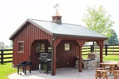 a small red shed with a grill and picnic table