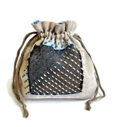 a small bag with blue and white designs on the front, sitting on a white surface