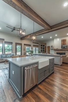 Rustic-elegant barndominium kitchen with quartz countertops, farmhouse sink, and modern appliances flowing into living area