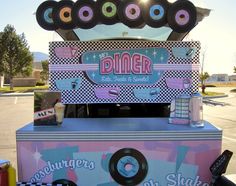 a pink and blue ice cream stand with doughnuts on top