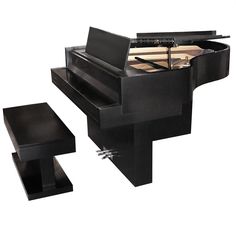 a black piano sitting on top of a wooden table