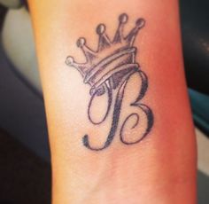 a small tattoo with a crown on it's wrist and the letter b written in black ink