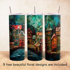 three tall candles with houses painted on them