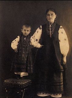 an old photo of two people standing next to each other