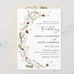 an elegant wedding card with flowers and greenery