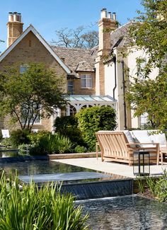 a house with a pool in front of it and some chairs around the water feature