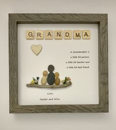 a wooden frame with some rocks in it and the words grandma spelled by scrabbles