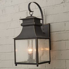 two light outdoor wall lantern against a white brick wall