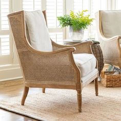 a living room with two chairs and a table in front of them on a rug