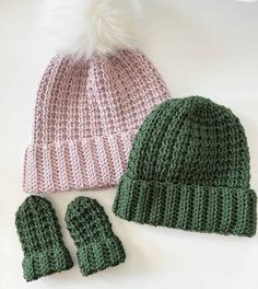 two knitted hats and mittens sitting next to each other