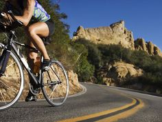 a woman riding a bike down a curvy road