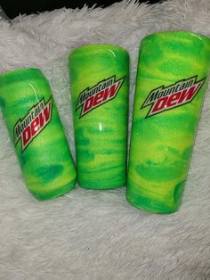 three green plastic cups sitting on top of a white blanket