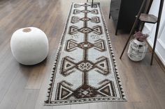 a white and brown rug sitting on top of a hard wood floor