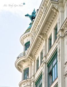 an old building with a statue on the top of it's roof and windows