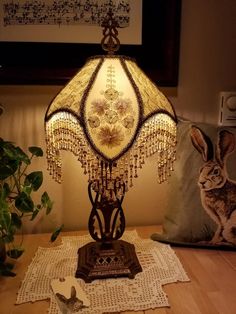 a lamp sitting on top of a table next to a pillow