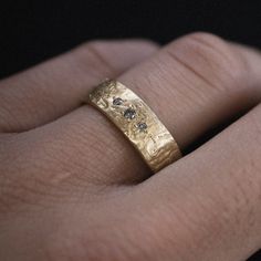 a close up of a person's hand with a gold ring