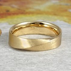 two gold wedding bands sitting on top of each other