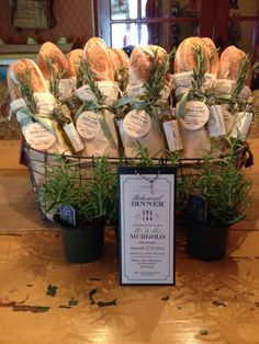 a basket filled with lots of flowers sitting on top of a wooden table next to a sign