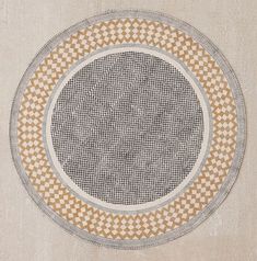 a round rug with an intricate design on the bottom in grey and tan tones,