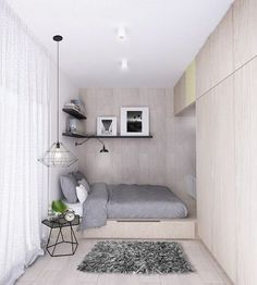 a small bedroom with a bed, desk and shelves on the wall next to it