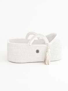 two white wicker baskets with tassels and handles, one is made out of woven material