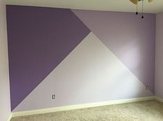 an empty room with purple and white walls