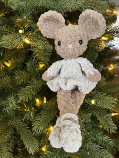 a teddy bear ornament hanging from a christmas tree