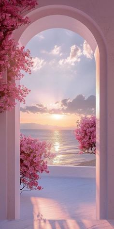 an archway leading to the beach with pink trees