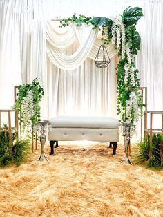 a white bench sitting in front of a window covered in flowers and greenery on top of a carpeted floor