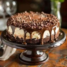 a chocolate cake with white frosting and chocolate toppings on a black platter