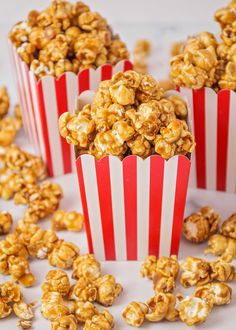 three red and white striped popcorn buckets filled with caramel flavored popcorn kernels