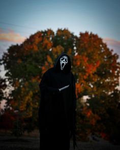 a person in a black hooded suit with a ghost mask on