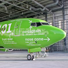 a large green airplane parked inside of a hangar