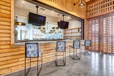 the inside of a restaurant with wooden walls and chairs in front of a large window