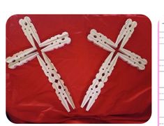 four wooden crosses sitting on top of a red cloth covered table next to a ruler