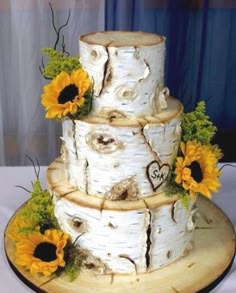 a three tiered cake with sunflowers on it