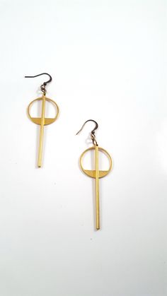 Simple and understated, these modern minimalist earrings are a great go to for everyday wear, to work or a night out. The earrings feature a long golden brass bar that is chin grazing through the middle of a brass geometric circle. These lightweight earrings hang about 2.75 inches in length while the circle hangs 1.5 inches length. The entire look is topped off with a nickel and lead free french ear wire. For more earrings check out our selection here: https://www.etsy.com/shop/DyNaModuo?section Modern Matte Gold Metal Earrings, Modern Metal Linear Earrings For Everyday, Modern Metal Linear Earrings For Everyday Wear, Modern Geometric Gold Hoop Earrings, Modern Matte Gold Earrings, Modern Gold Geometric Hoop Earrings, Elegant Adjustable Geometric Earrings, Minimalist Metal Plug Earrings For Everyday, Gold Geometric Earrings For Everyday