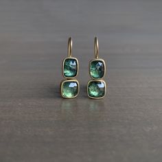 An enchanting forest of lush green - with subtle hints of blue - sways effortlessly from the lobe in this elegant pair. Sapphires, 7.90 carats total weight 22k yellow gold bezels 18k yellow gold ear wires Earrings measure 1/4" at the widest and hang 11/16" from the ear Classic Green Earrings With Bezel Setting, Green Bezel Set Earrings For Formal Occasions, Formal Green Earrings With Bezel Setting, Emerald Earrings With Bezel Setting As A Gift, Emerald Bezel Setting Earrings For Gift, Emerald Earrings With Bezel Setting For Gift, Elegant Emerald Earrings With Bezel Setting, Green 14k Gold Earrings With Bezel Setting, Yellow Gold Bezel Setting Earrings For May Birthstone