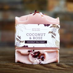 a bar of coconut and rose handmade soap on a wooden table next to a brick wall