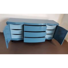 a blue dresser with three drawers and two doors