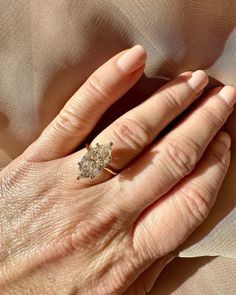 an older woman's hand with a diamond ring on top of her left hand