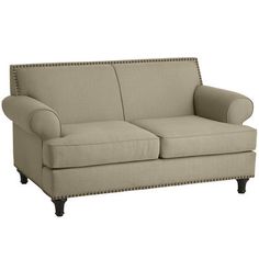 a beige couch with studding on the armrests and back rest, sitting against a white background