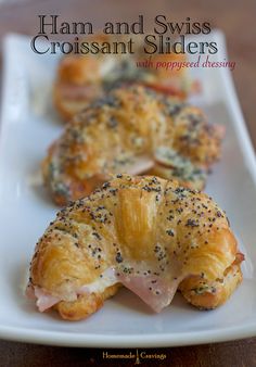 ham and swiss croissant sliders on a white plate with poppy seed crusts